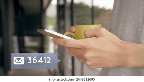 Close up of a hand typing on a mobile phone while the other hand is holding coffee mug. In the left corner a digital image of a message bubble containing an email icon with a number count up.  - Powered by Shutterstock - Get 15% off with code: PIKWIZARD15