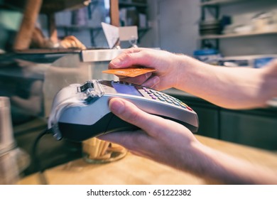 Close up of a hand using a contactless credit card terminal to pay