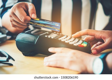 Close Up Of Hand Using Credit Card To Pay By Sending The Credit Card To The Staff At The Credit Card Swipe Machine. Online Payment