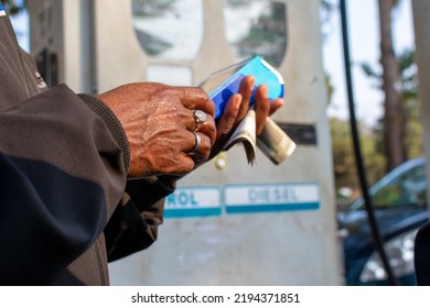 Close up of hand using credit card swiping machine to pay in petrol pump in India. Man entering credit card code in swipe machine. Online payment, financial inclusion concept. Selective focus.