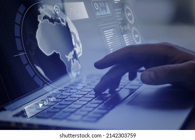 Close up of hand using laptop computer with creative glowing digital business screen interface, globe and charts on blurry background. Spy, hud and world concept. Double exposure