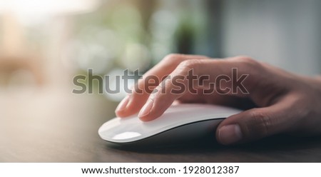 Close up of hand using on white mouse and clicking on office table.