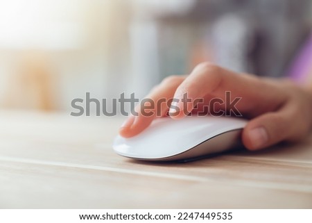 Close up of hand using on white mouse and clicking on office table.