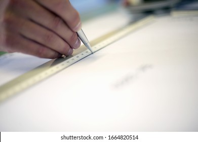 Close up of a hand using a ruler to draw a line