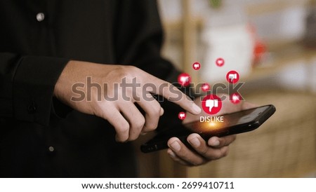Close up hand using smartphone with floating dislike icons. Negative social media reaction, online feedback, internet criticism, and digital communication concept for social network users.