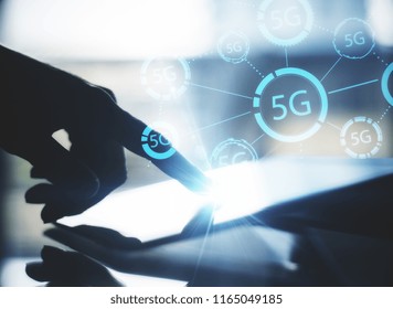 Close up of hand using tablet with glowing 5G internet hologram. Connection and speed concept. Double exposure
