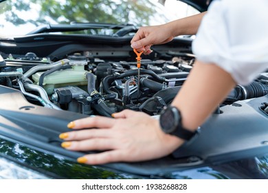 Close Up Hand Of Woman Check The Oil Level In Car Engine.