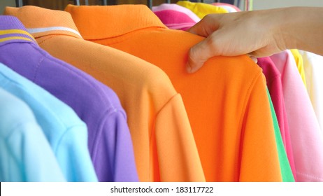 Close Up Hand Of Woman Choosing Colorful Polo Shirt Shopping At Store