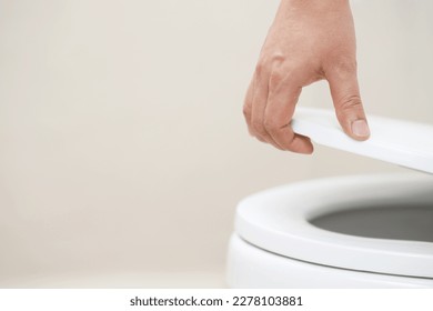 close up hand of a woman closing the lid of a toilet seat. Hygiene and health care concept. - Shutterstock ID 2278103881