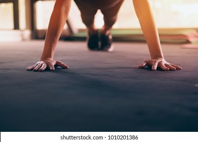 Close Up Hand Of Woman Doing Push Ups In The Gym. Light And Silhouette.