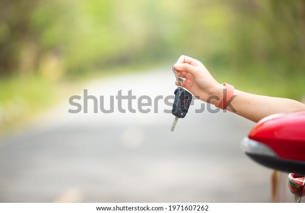 Close up of hand woman driver showing car keys on\
car door