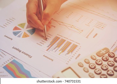 close up hand woman holding pen pointing on summary report chart and calculate finance.