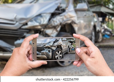 Close up hand of woman holding smartphone and take photo of car accident - Powered by Shutterstock