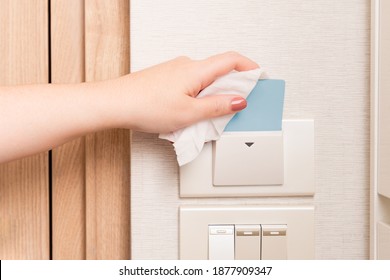 Close Up Hand Of A Woman Using Sanitizer Wet Wipe Grab Key Card From The Holder. New Normal Travel Safe During Covid-19 Pandemic. Disinfection, Alcohol 70%, Hotel, Accommodation, Prevention, Reopening