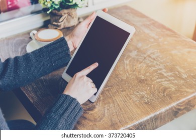 Close up hand woman using tablet in coffee shop with vintage tone. - Powered by Shutterstock