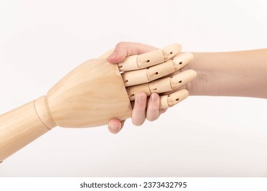 Close up of the hand of wooden mannequin hand shaking human hand. Hands concept. Hope. Help. Concept.  - Powered by Shutterstock