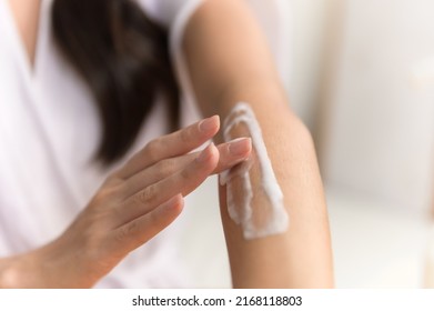 Close Up Hand Of Young Asian Woman Applying Skin Care Cream Lotion On Her Arm. Woman Beauty Selfcare Cosmetic Caring Routine Concept.