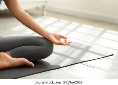 Close up hand of young woman sit on yoga mat breathing with yoga lotus pose.Yoga meditation of young healthy woman relax and comfortable at white cozy home,Yoga Exercise for Wellness Concept - Powered by Shutterstock