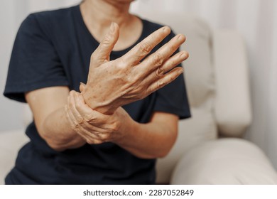 Close up hands of asian senior elderly woman with parkinson's disease symptom, hand numbness, finger lock, hand pain. Mental health and elderly care concept - Powered by Shutterstock