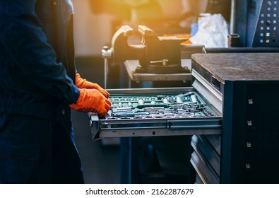 Close up of hands of auto mechanic selecting tools in car repair shop - Powered by Shutterstock