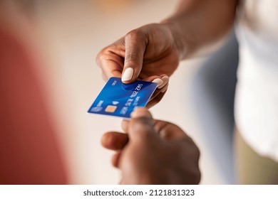 Close Up Hands Of A Black Woman Giving Bank Credit Card To Man. Detail Shot Of A Woman Passing A Payment Credit Card To The Seller. Hand Of African American Man Receiving Payment From Customer.