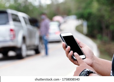 Close Up Hands Calling For Help With The Mobile Phone. The Car Has A Road Accident. Insurance Concept
