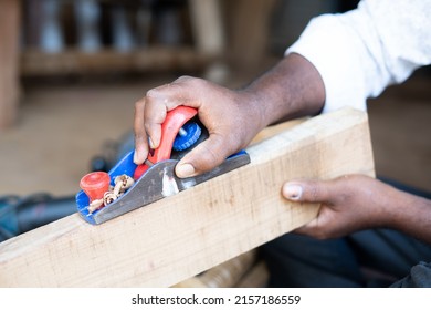 Close Up Hands Of Carpenter Busy Working By Using Block Plane For Removing Rough Surfaces On Wood At Shop - Concept Of Artisans, Self Employed And Skilled Labour