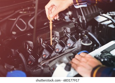 Close up hands checking lube oil level of car engine from deep-stick for service and maintenance concept vintage tone. - Powered by Shutterstock