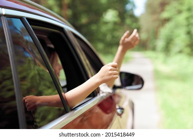 Close up of hands of child and adult outside car                               