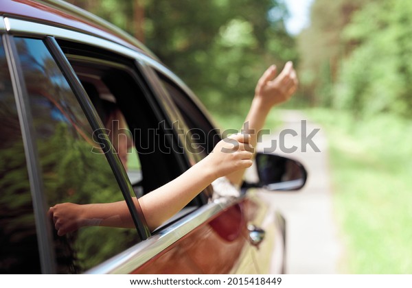Close up of hands of child and adult outside car   \
                          \
