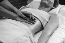 Close Up Hands Of Chiropractor Or Masseur Making Relaxing Abdominal Massage To Lying Young Fit Woman At Wellness Spa Cabin.