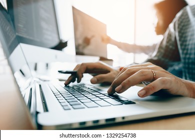 Close up of hands contemporary website developer man typing and writing code for program website and working with partner in office.