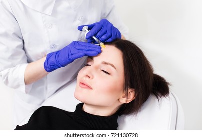 Close Up Of Hands Of Cosmetologist Making Botox Injection In Female Face