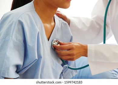 Close Up Hand's Doctor Hold Stethoscope Exam Check Heart  Of Young Woman Checkup In Hospital Medical Care Concept