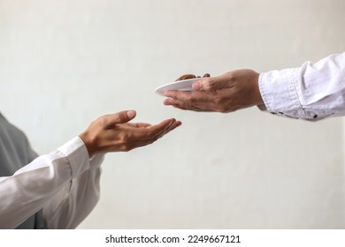 Close up hands giving dates fruit and other hand accept it on white background. Iftar and ramadan kareem concept.  - Shutterstock ID 2249667121