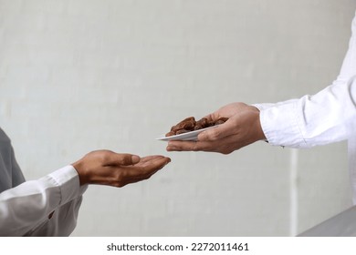 Close up hands giving dates fruit and other hand accept it on white background. Iftar and ramadan kareem concept. - Shutterstock ID 2272011461