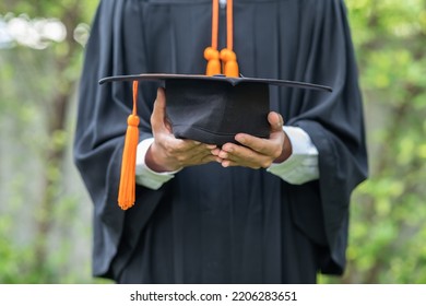 Close Up Hands Of Graduate Man Holding Graduation Cap Celebrating So Proud And Happiness In Commencement Day. Congratulation Of Student In Graduation Day. Education Success Concept. Graduation Hat.