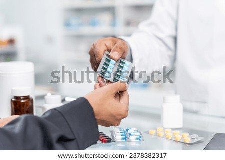 Close up hands of Handsome asian male selling pharmacist and female customer buying medicine in the pharmacy drugstore, hand over capsule pills of medicine from hand to another hand charge.
