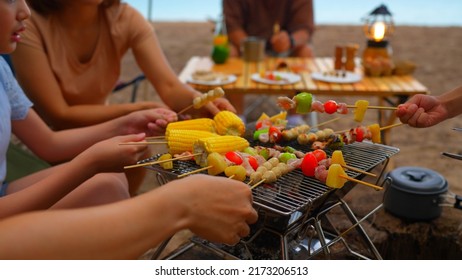 Close up hands of Happy family eating barbecue together, Cooking grilled bbq dinner outside beach, enjoy summer on the beach enjoy on weekend people lifestyle. - Powered by Shutterstock