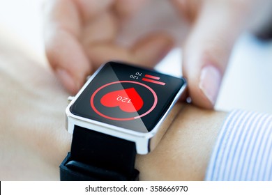 close up of hands with heart icon on smartwatch
