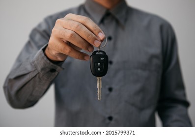 Close Up Hands Holding Car Keys. Man Holding Key Of Car Giving To Agent Of Insurance For Sell. Business Investment Insurance Car Seizure And Car Concept.