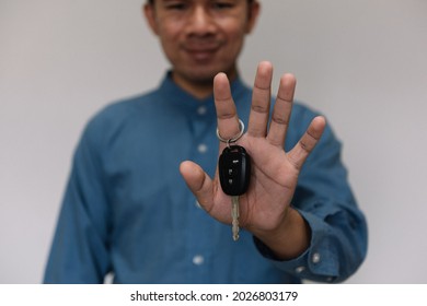 Close Up Hands Holding Car Keys. Man Holding Key Of Car Giving To Agent Of Insurance For Sell. Business Investment Insurance Car Seizure And Car Concept.