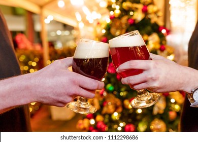 Close Up Of Hands Holding Christmas Pretzel And Beers 