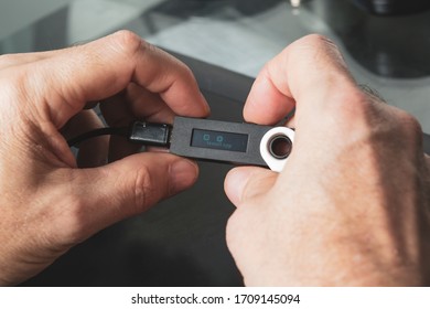 Close Up Of Hands Holding A Hardware Wallet 