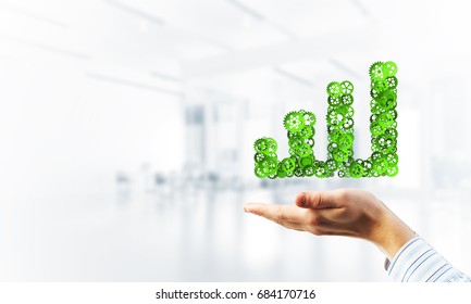 Close of hands holding in palms growing graph made of gears - Shutterstock ID 684170716