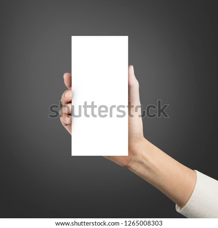 Close up hands holding paper blank brochure a4 three template on a grey background.