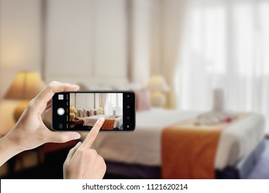 Nahaufnahme von Händen, die Smartphone halten, Foto-Schlafzimmer im Hotel