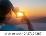 Close up of hands making frame gesture with sunset, Female hand capturing the sunrise. Planning and vision concept
