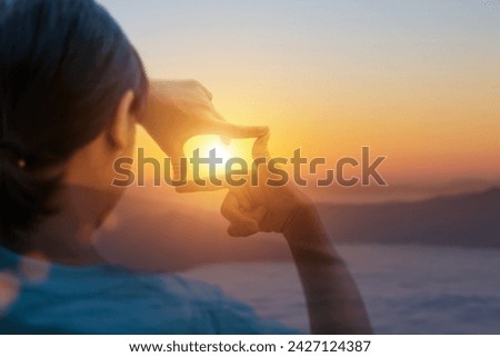 Close up of hands making frame gesture with sunset, Female hand capturing the sunrise. Planning and vision concept