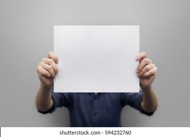 Close Up Hands Man Holding Behind A Paper Blank For Banner On Gray Background